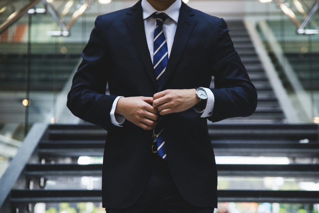 Image of a man wearing a jacket and tie, with his head cut off.