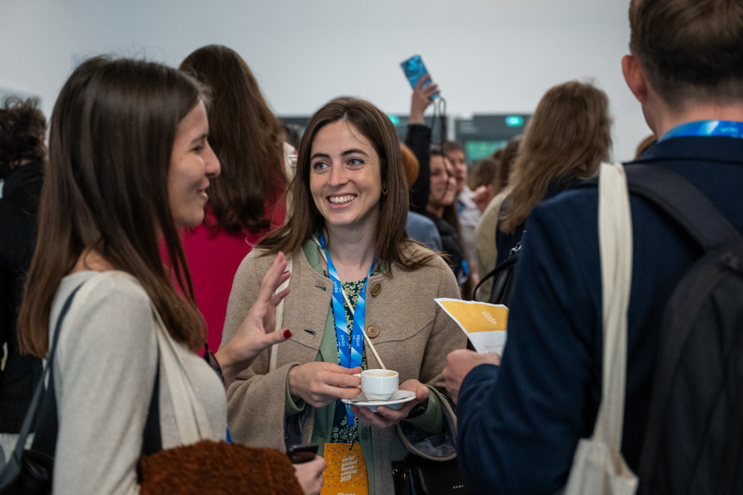 Partecipanti a un evento scambiano impressioni durante una pausa caffè.