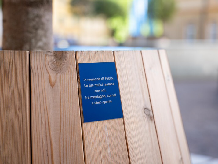 Rivestimento in legno con una piccola targa commemorativa su sfondo sfocato.