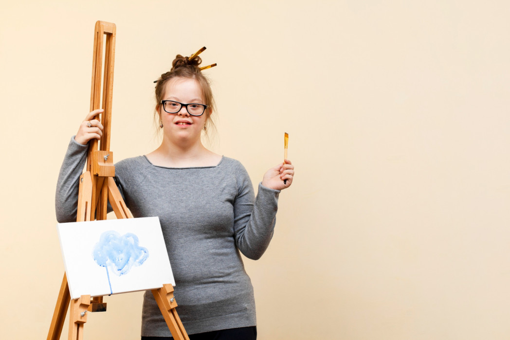 Frau mit Down Syndrom vor Malereistaffel