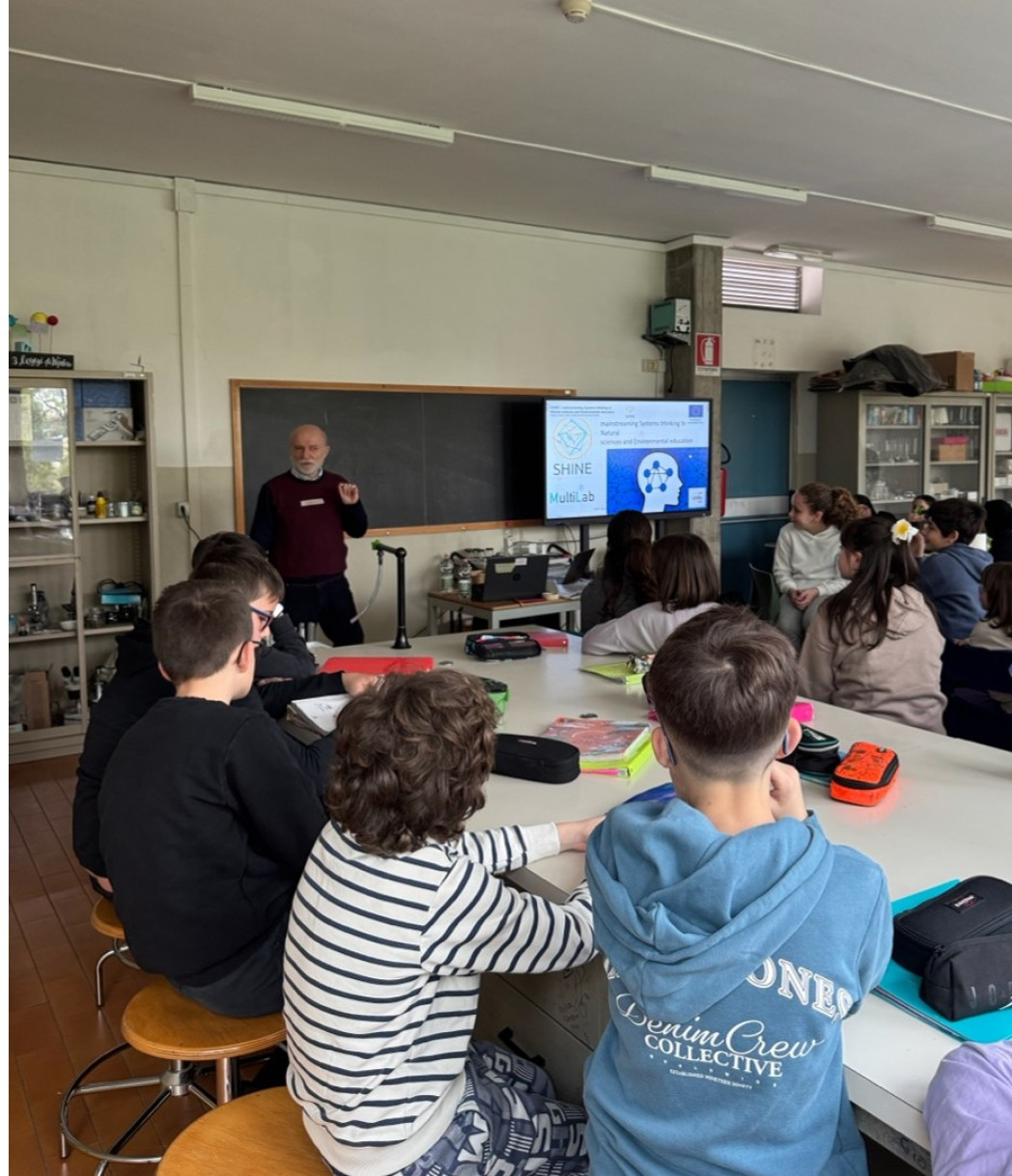 Un gruppo di bambini seduti attorno a un tavolo partecipa a un'attività guidata da un adulto