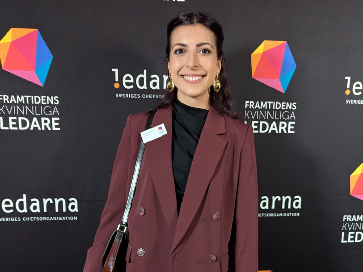 Young woman in front of a panel with logos