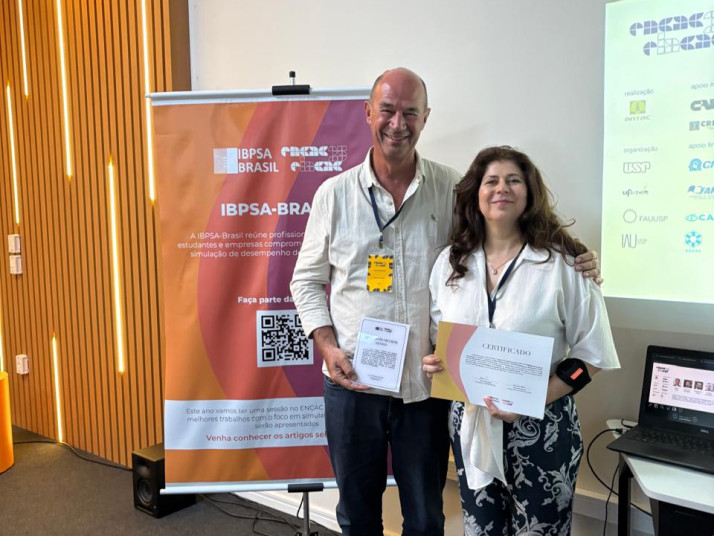 Joyce Correna Carlo (right) receives the awards from Roberto Lamberts, a board member from IBPSA-Brasil.