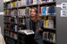 Frau mit Buch in der Hand vor Bücherregal