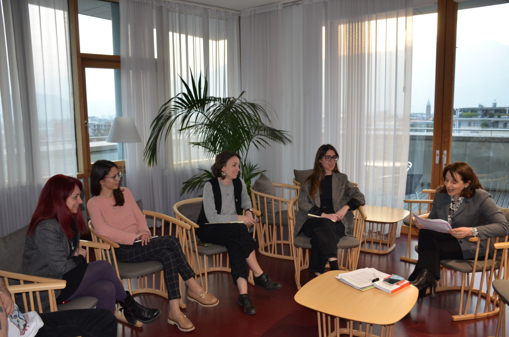 Cinque donne attorno ad un tavolo.