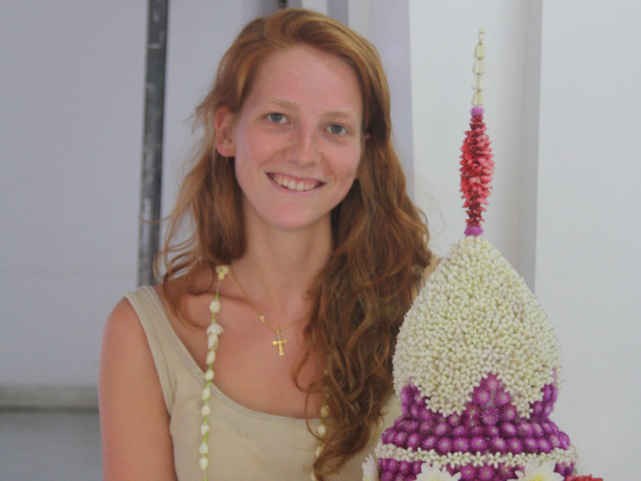 Lächelnde Frau mit asiatischer Blumenschale in der Hand