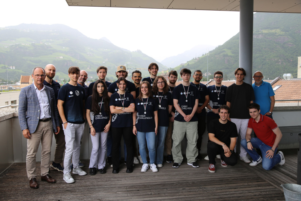Venti persone sono in piedi in una terrazza dell'Università.
